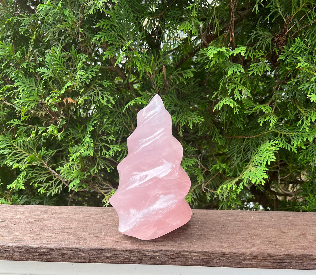 This amazing, hand carved and polished gemstone quality Rose quartz crystal flame is one of a kind! .Rose Quartz can be effective in attracting new love and raises one&#39;s self-love and self esteem. Height: 8 1/4 inches Width: 5 inches 5.38 lbs