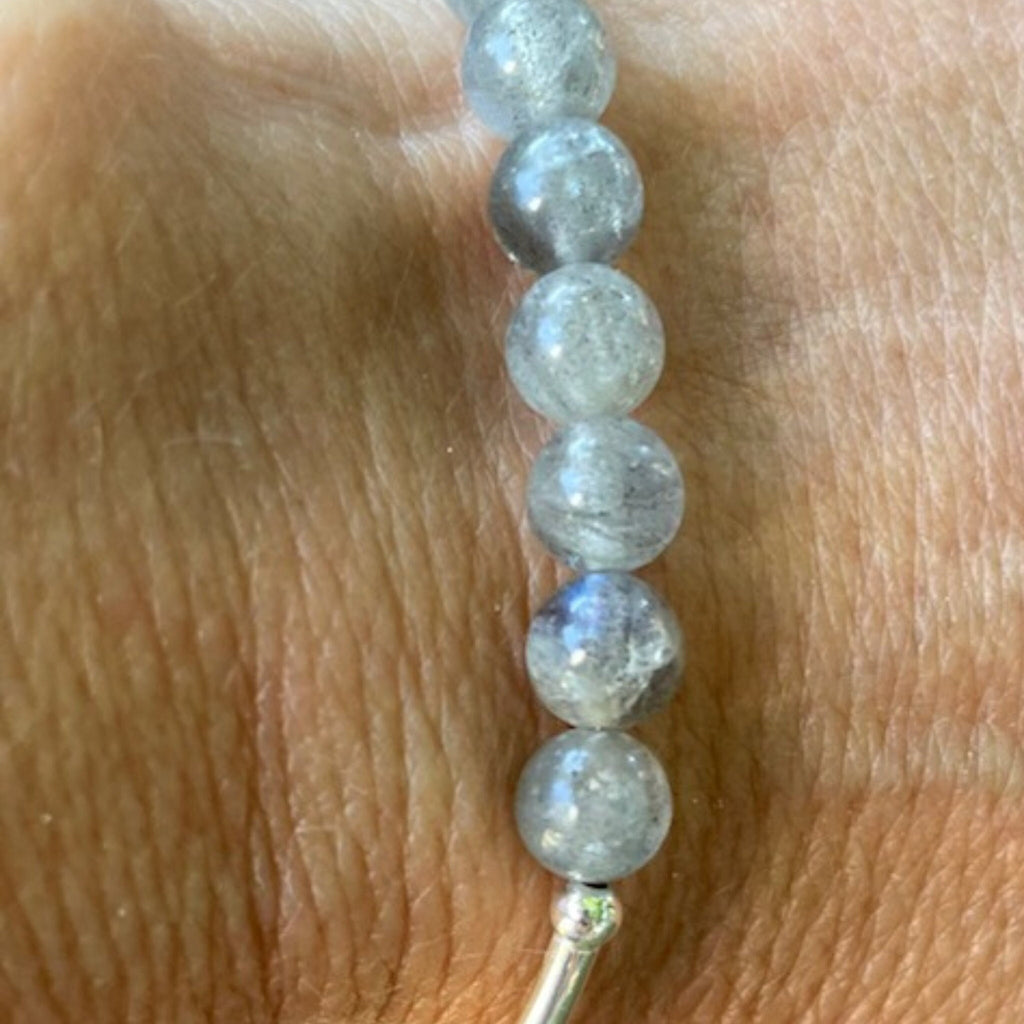 Labradorite Sterling Silver Bracelet - This iridescent Labradorite bracelet is a mystical and protective gemstone. The silver spacer looks like a smile! You will be reminded to smile everytime you wear it! Stretchable nylon, 7.25&quot; fits mosts.